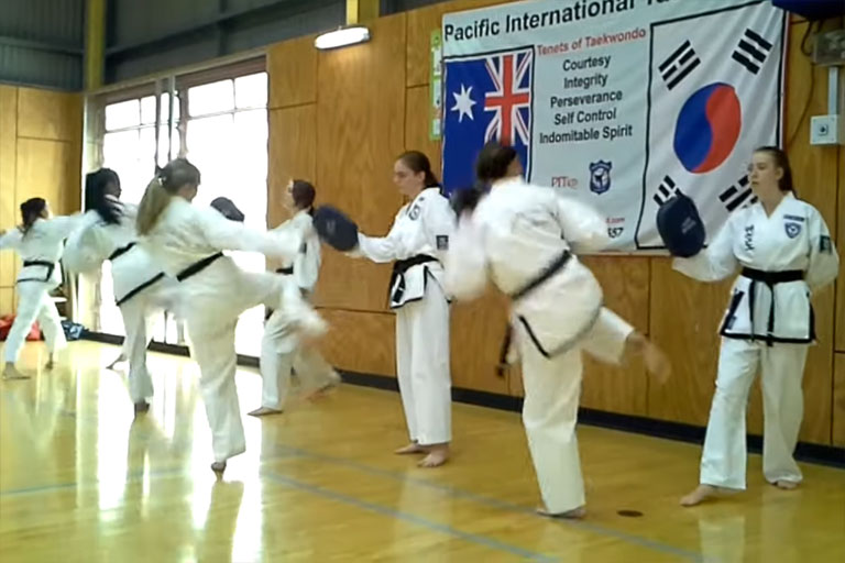girls practice taekwondo kicks