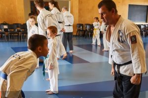 young boy bows to taekwondo instructor