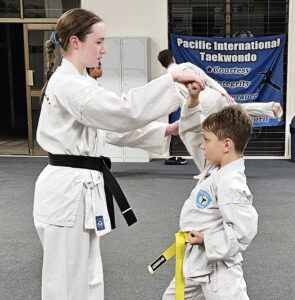 Black Belt instructing small boy