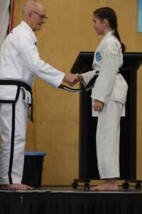 Junior girl being presented with a Junior Black Belt